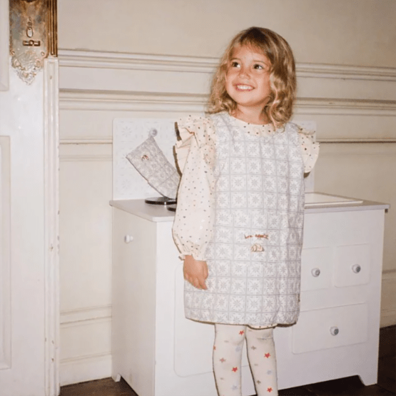 un tablier et ses accessoires Konges Slojd, vue de derrière sur fond blanc