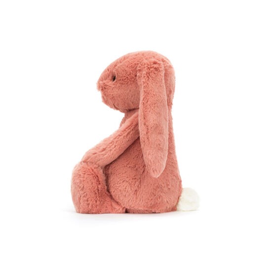 Un doudou lapin rose argile Jellycat, vue de côté sur fond blanc